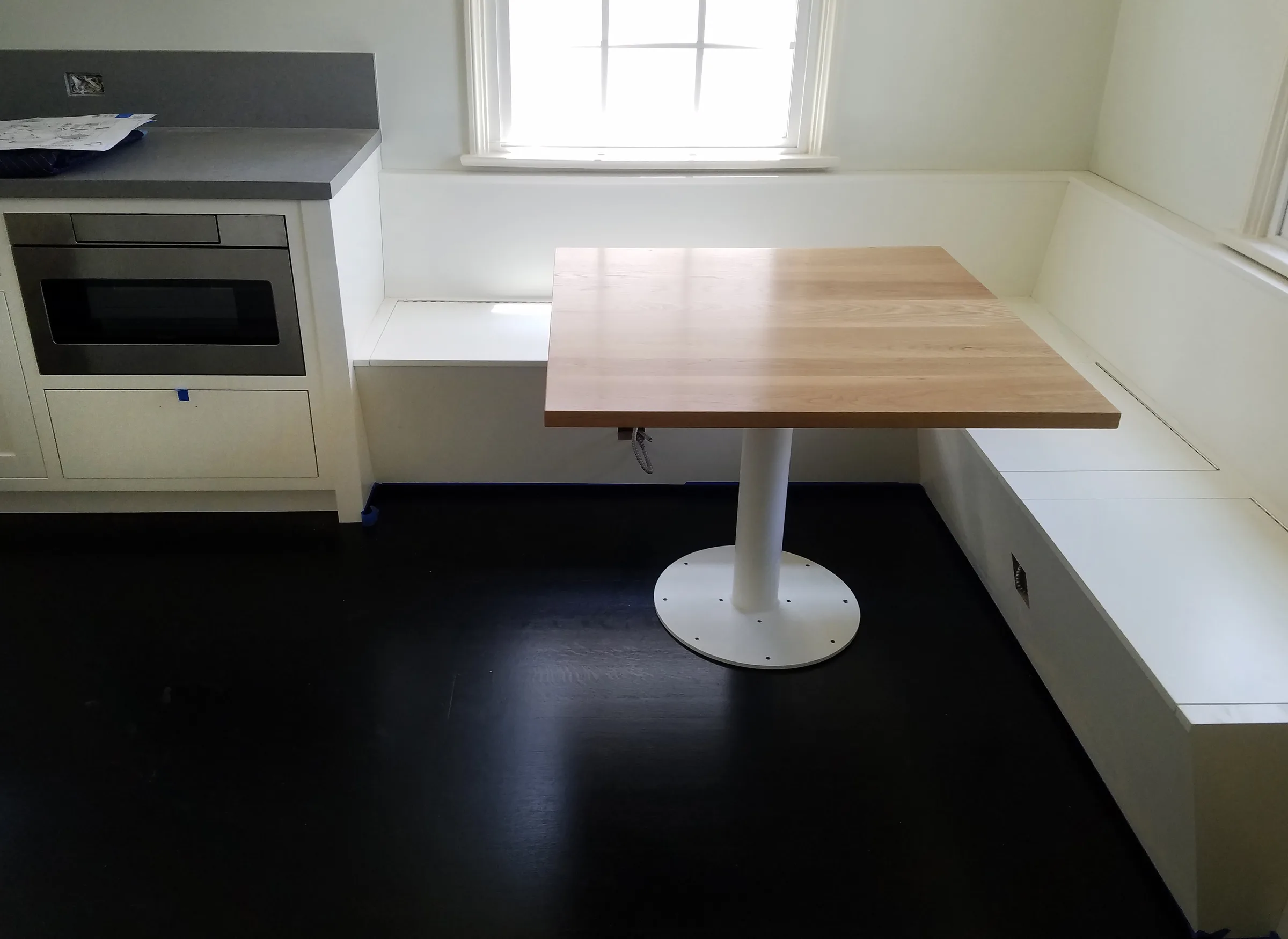 Built-in white banquette and a maple table on a white pedestal in a kitchen nook — furniture and millwork designed and built by Jack Rusk (Oakland and Los Angeles, 2013–2018)