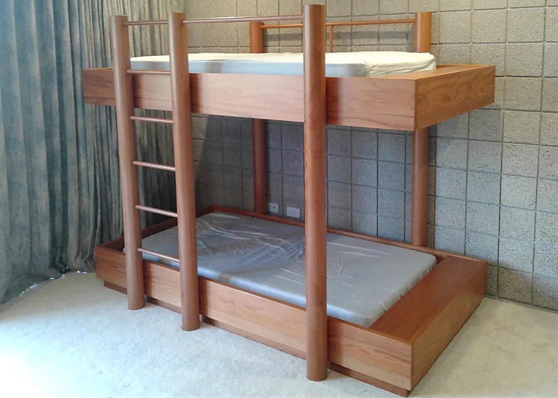 Redwood bunk bed with round posts and a ladder, in a room with a textured block wall — furniture and millwork designed and built by Jack Rusk (Oakland and Los Angeles, 2013–2018)