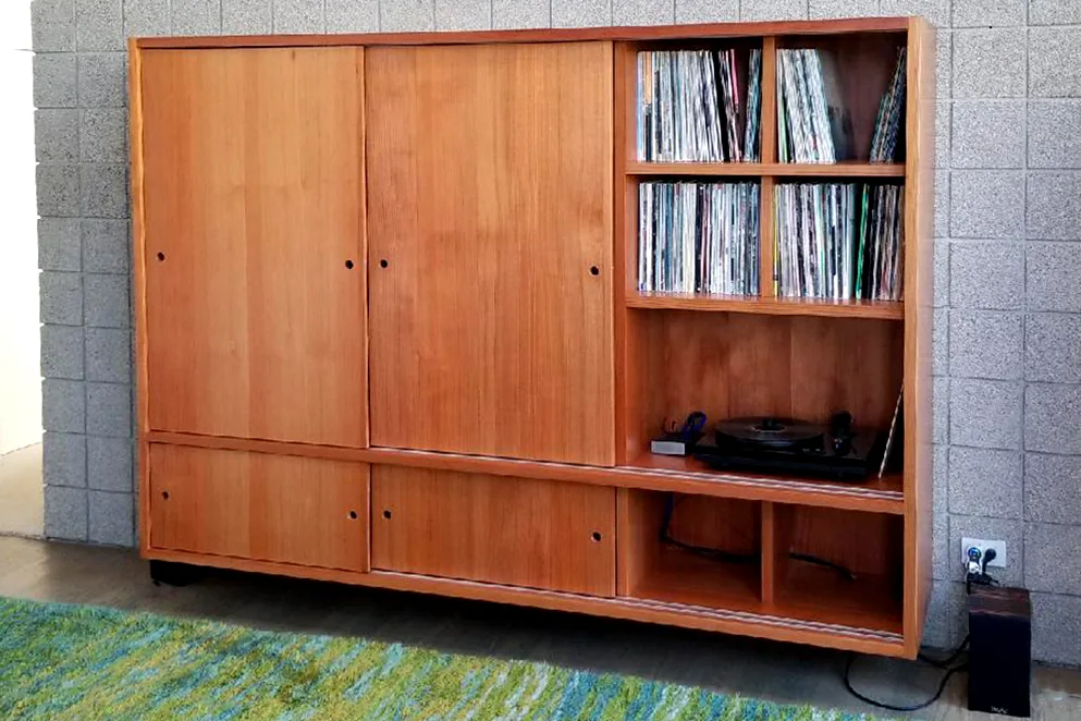 Redwood cabinet with sliding doors and open shelves of vinyl records against a block wall — furniture and millwork designed and built by Jack Rusk (Oakland and Los Angeles, 2013–2018)