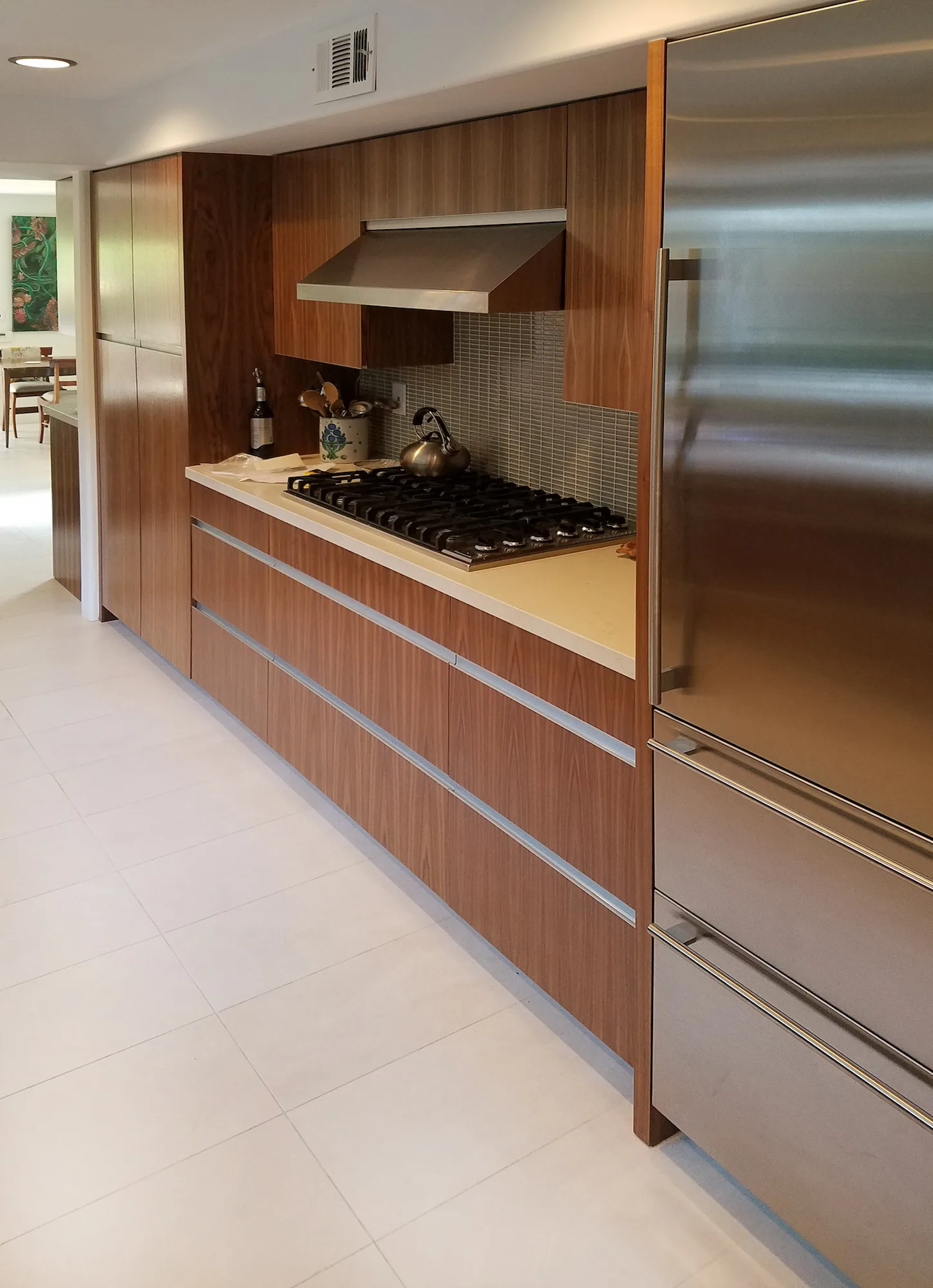 Galley kitchen with walnut cabinets, a gas cooktop and a stainless steel refrigerator — furniture and millwork designed and built by Jack Rusk (Oakland and Los Angeles, 2013–2018)