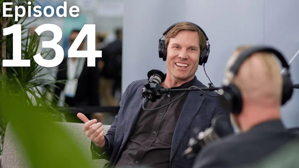 Digital Builder episode 134: Jack Rusk smiling in headphones at a podcast microphone, gesturing as he talks with a host seen from behind